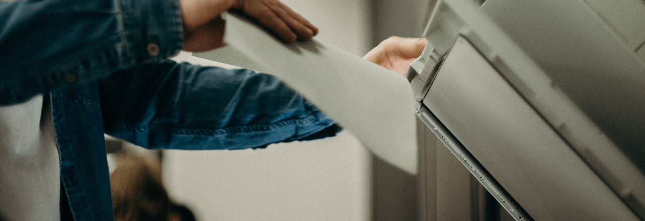 hand putting paper in printer