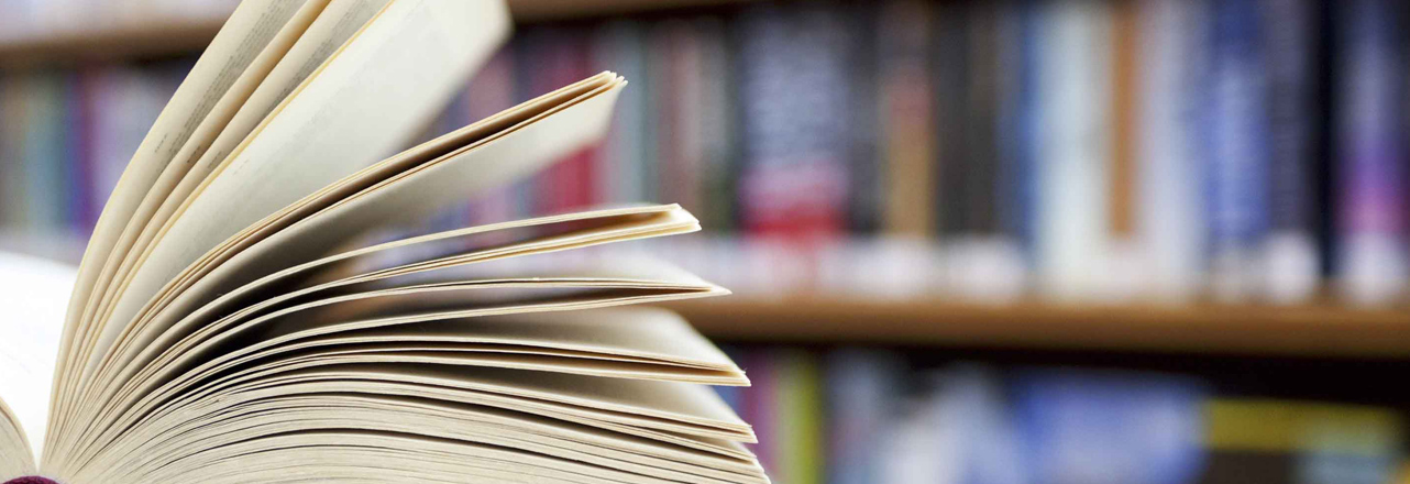 book lying open with book shelf in background