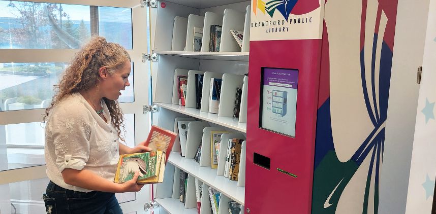 Lady standing at self serve book kiosk machine