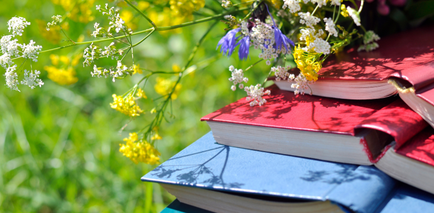 photo of books in a field of wildflowers